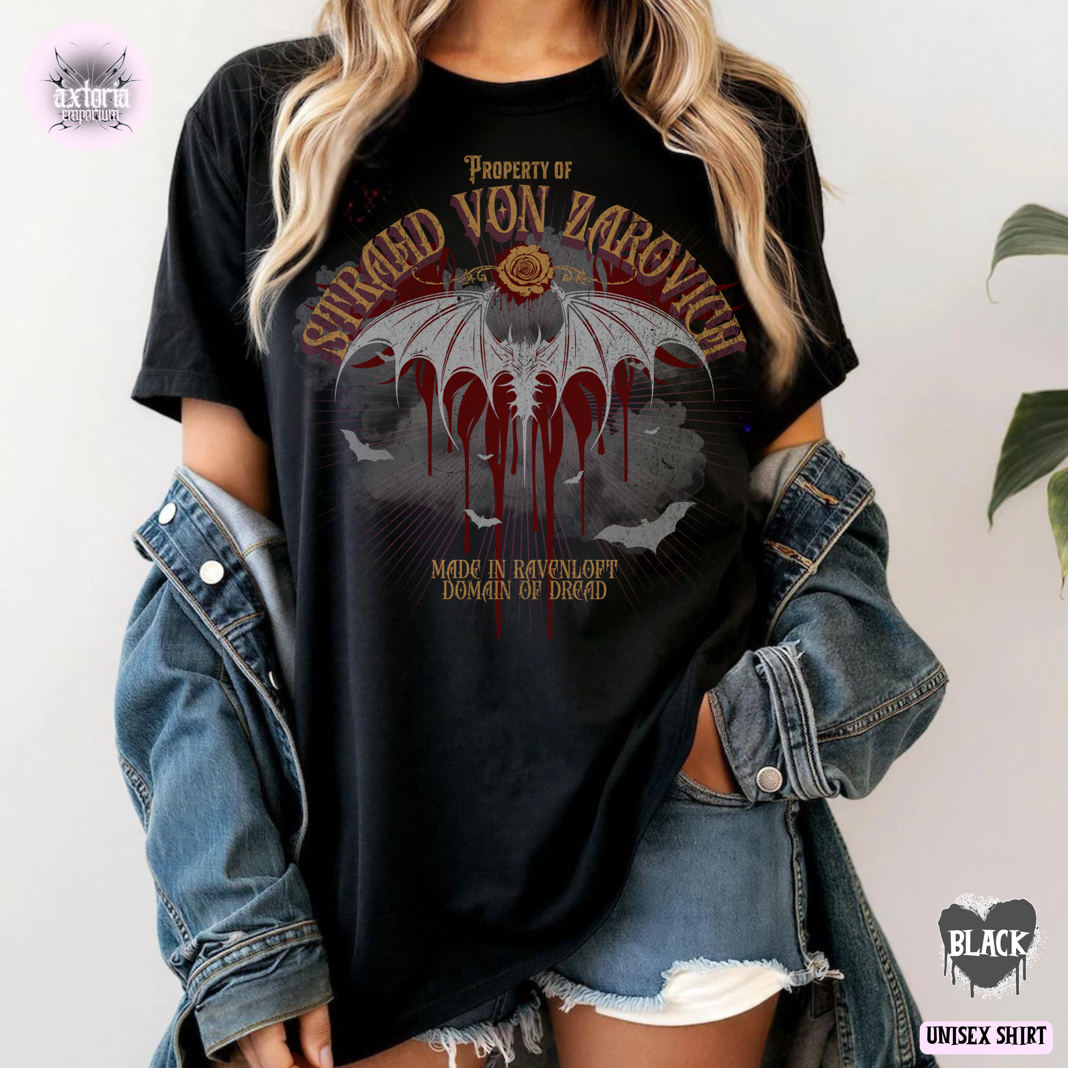 Person wearing a black ungeons and Dragons t-shirt with a Curse of Strahd graphic design and text saying "Property of Strahd von Zarovich, Made in Ravenloft. Domain of Dread"