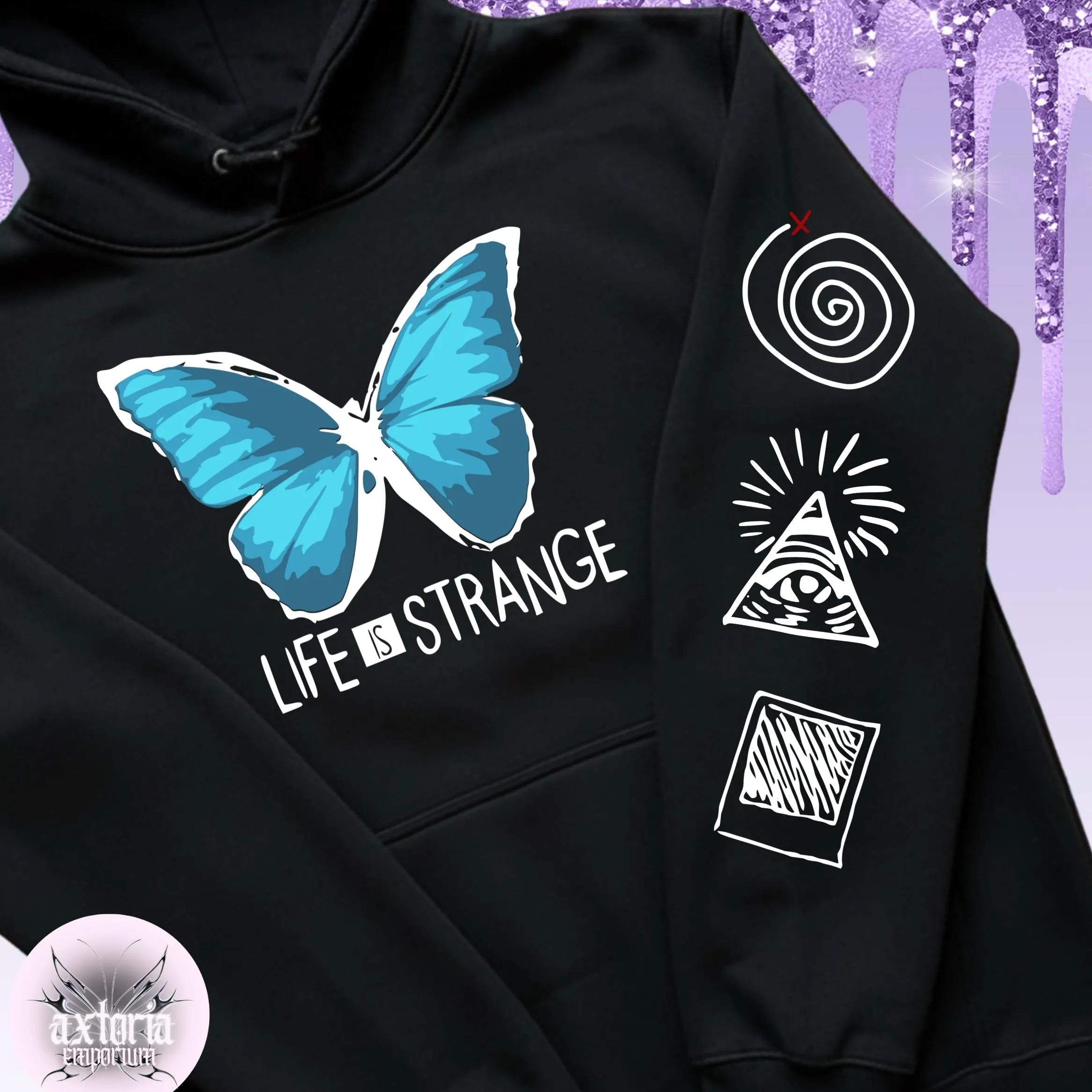 Black hoodie with blue butterfly graphic and text 'Life is Strange' on a glittery purple background.